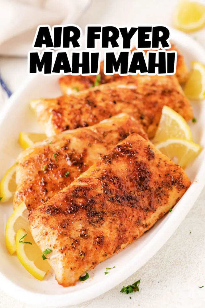 Lemon pieces next to air fryer mahi mahi.