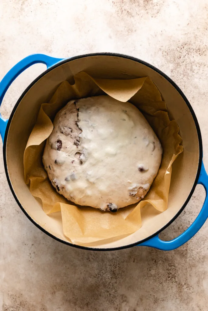 Unbaked olive bread in a dutch oven.