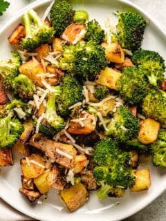 Close up view of roasted potatoes and broccoli with parmesan cheese.