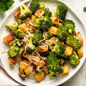 Close up view of roasted potatoes and broccoli with parmesan cheese.