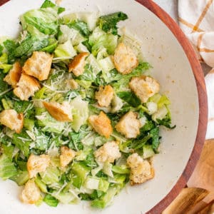 Close up view of caesar salad in a white bowl.
