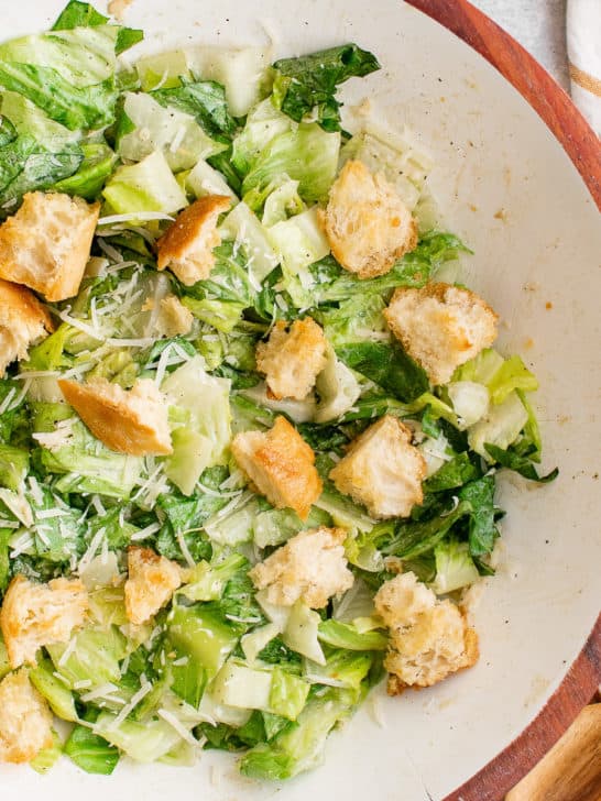 Close up view of Caesar Salad in a white bowl.