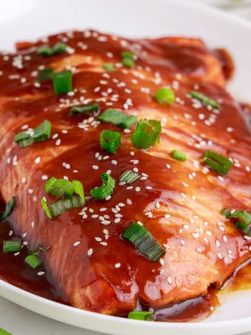 Close up view of teriyaki salmon on a platter.