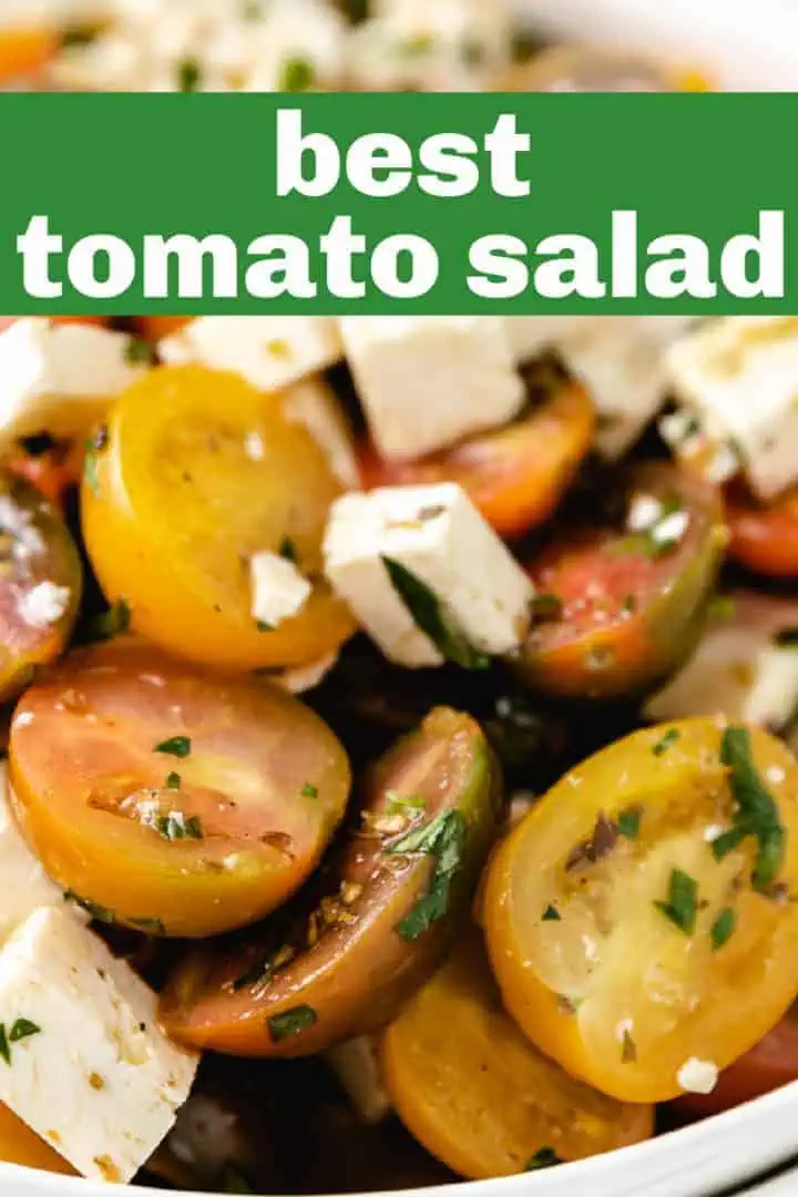 Close up view of tomatoes tossed with cheese and dressing.