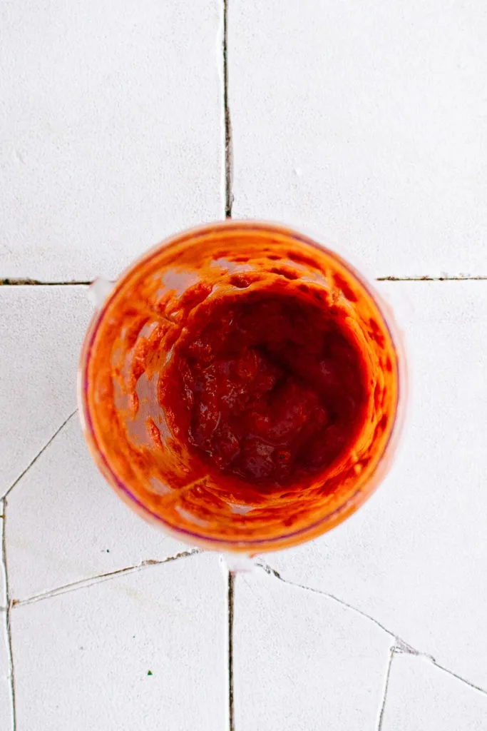 Top down view of chiles and adobo, lime juice, and seasonings in a cup.