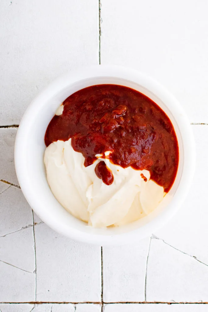 Top down view of chipotle paste and mayo in a bowl.