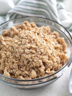 Angled view of a bowl of crumble topping.