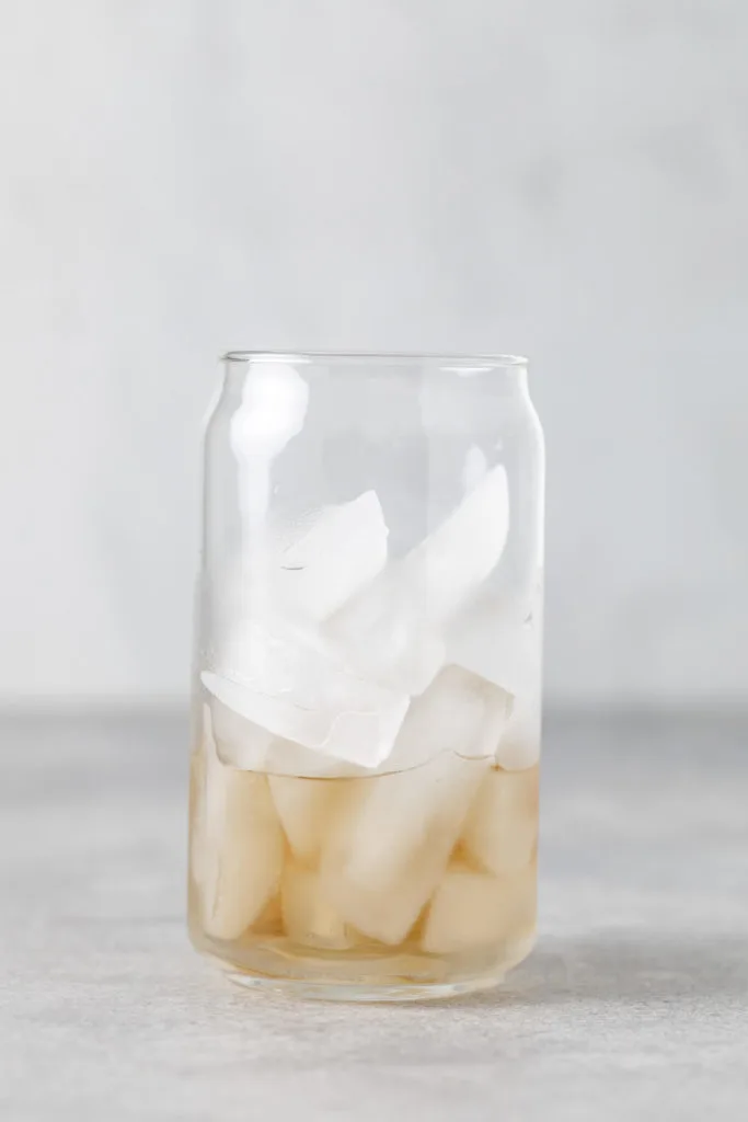 Vanilla syrup poured into a glass over ice.