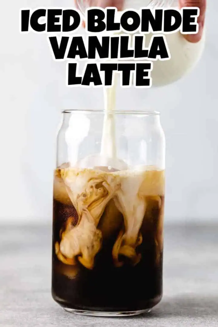 Milk being poured into a glass of espresso.