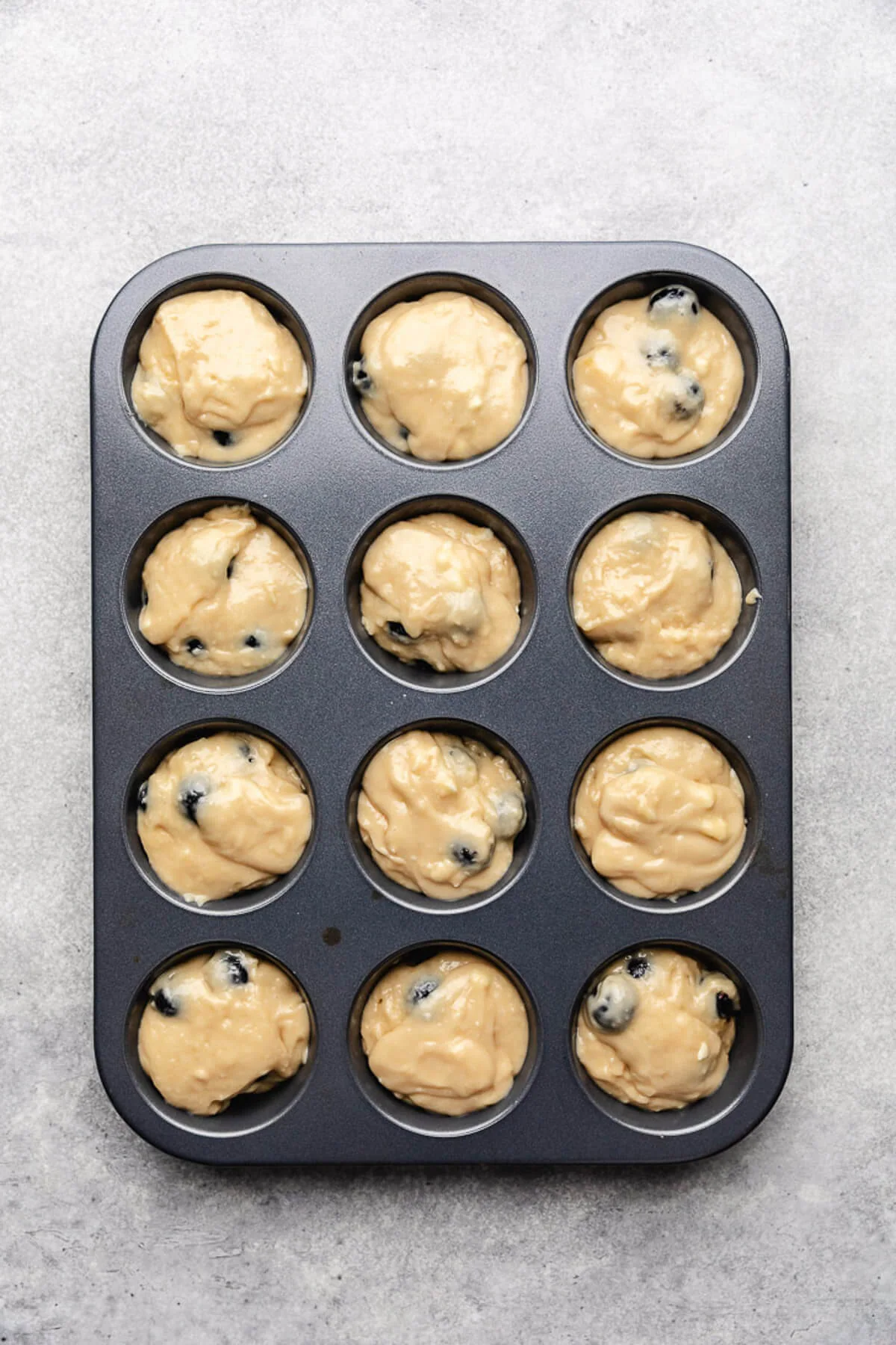 Blueberry Muffins Unbaked muffin batter in a pan.