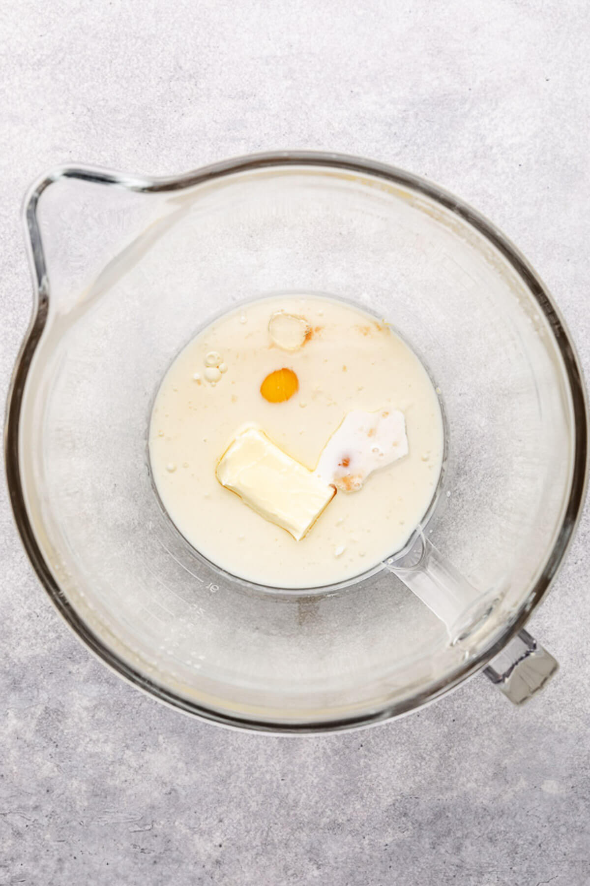 Eggs, butter, oil, vanilla, and milk in a mixing bowl.