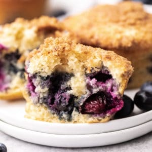 Blueberry muffins on a stack of plates.
