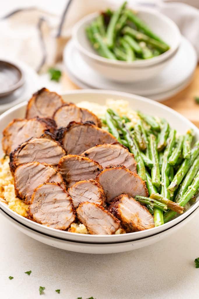 Pork tenderloin on top of mashed potatoes.