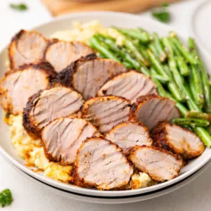 Close up view of seasoned pork slices on plates.