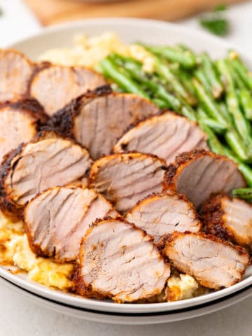 Close up view of seasoned pork slices on plates.
