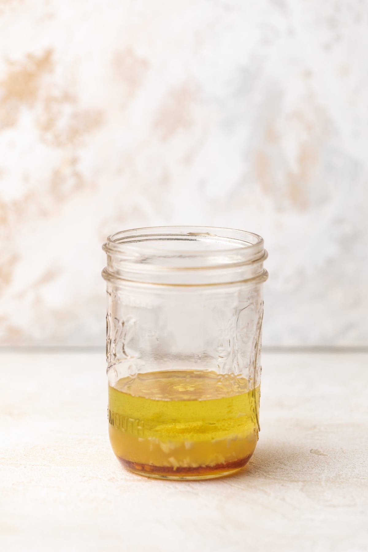 Tall jar of salad dressing ingredients.