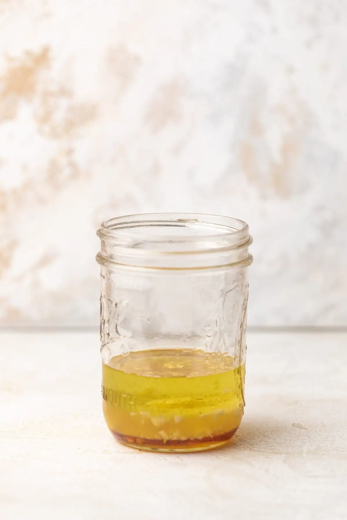 Tall jar of salad dressing ingredients.