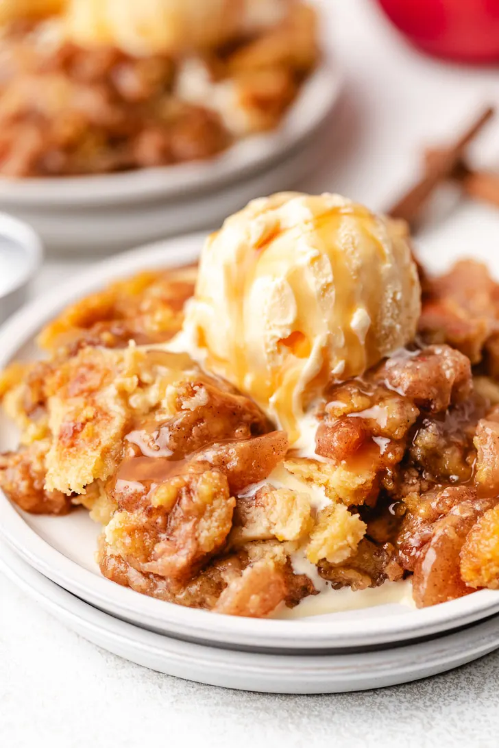 Ice cream on apple dump cake with caramel sauce.