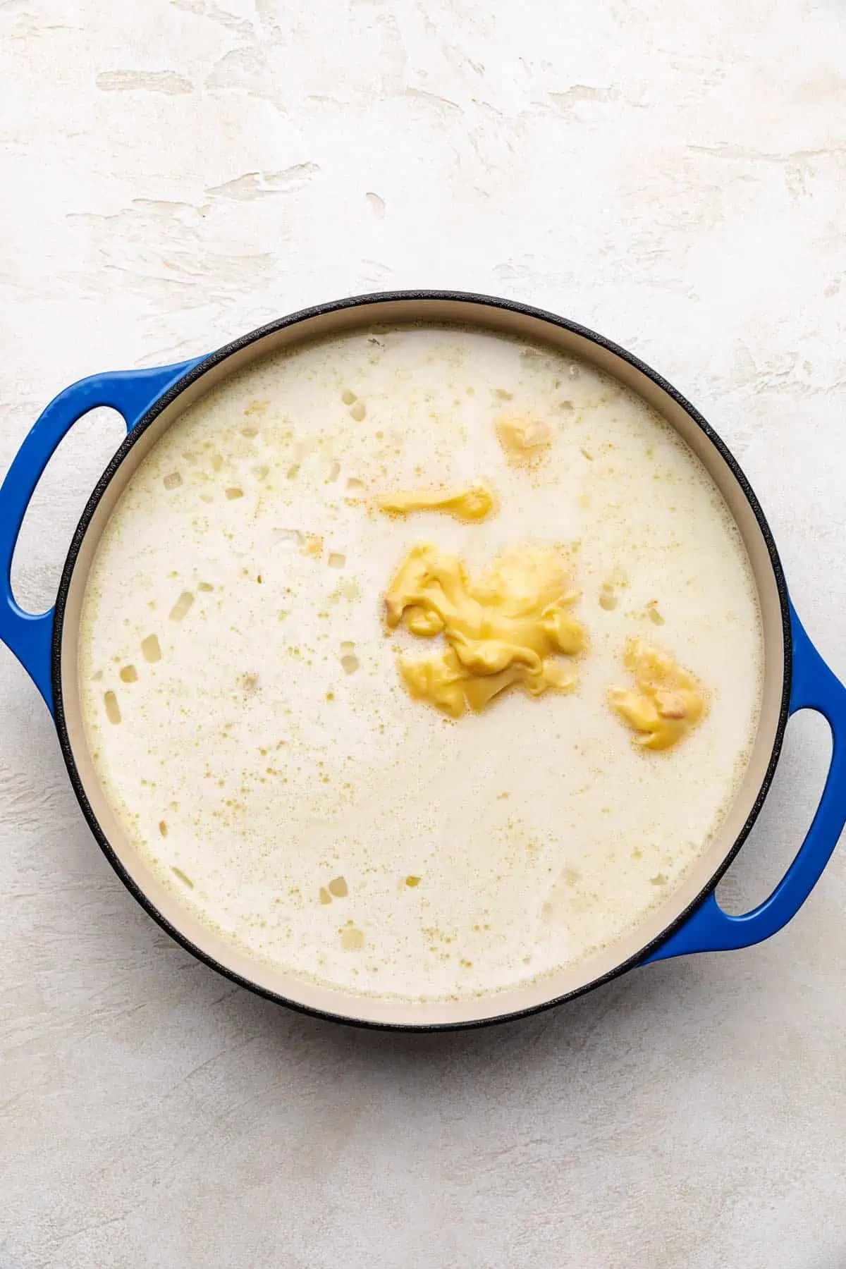 Broth, cream of chicken soup, water, and heavy cream added to sauteed onions.