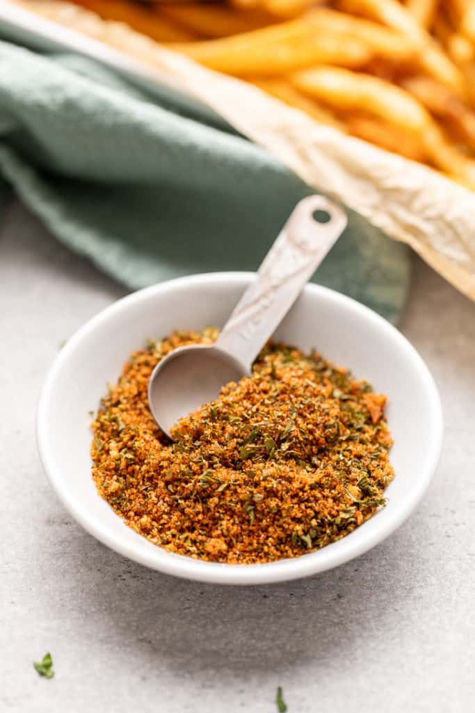 French fry seasoning with a metal measuring spoon.