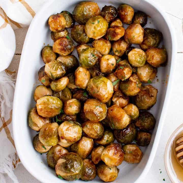 Top down view of a serving dish of honey and sriracha brussels sprouts.