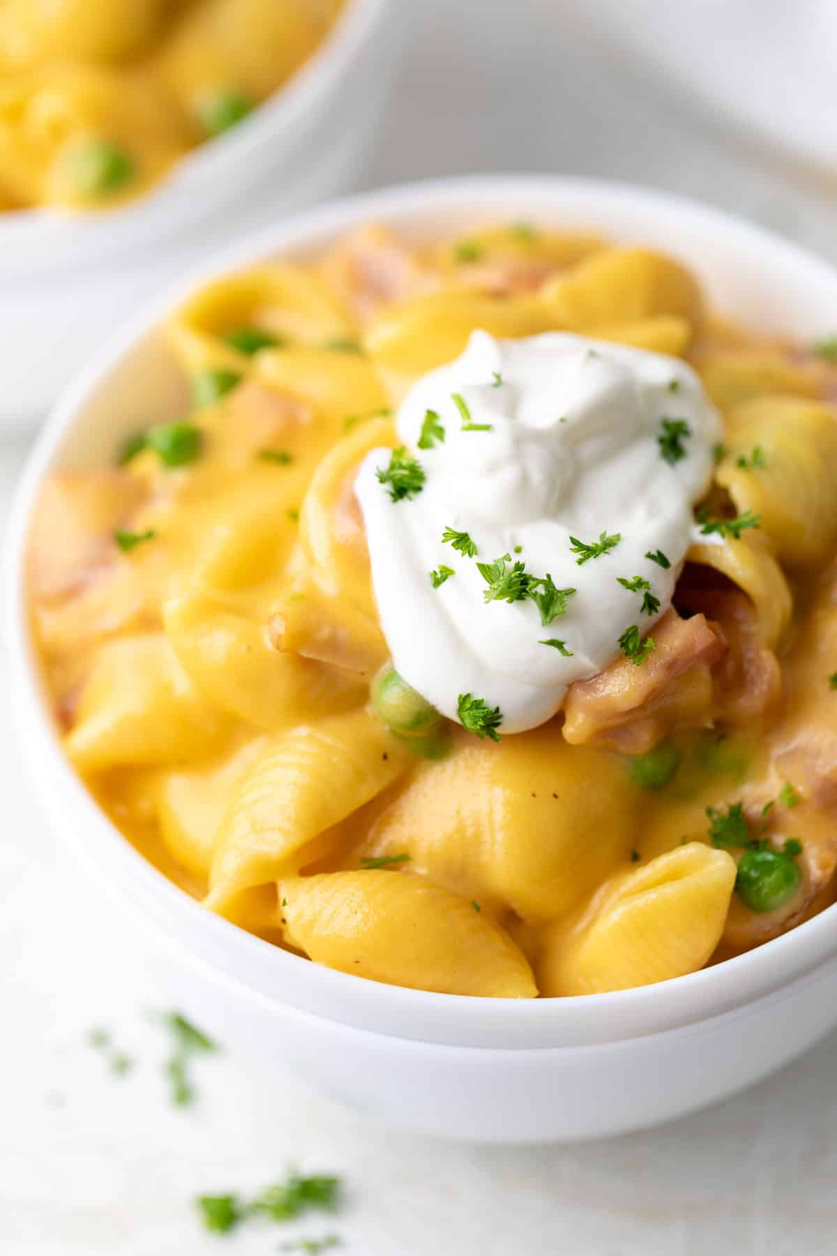 Sour cream and parsley on top of shells and cheese.