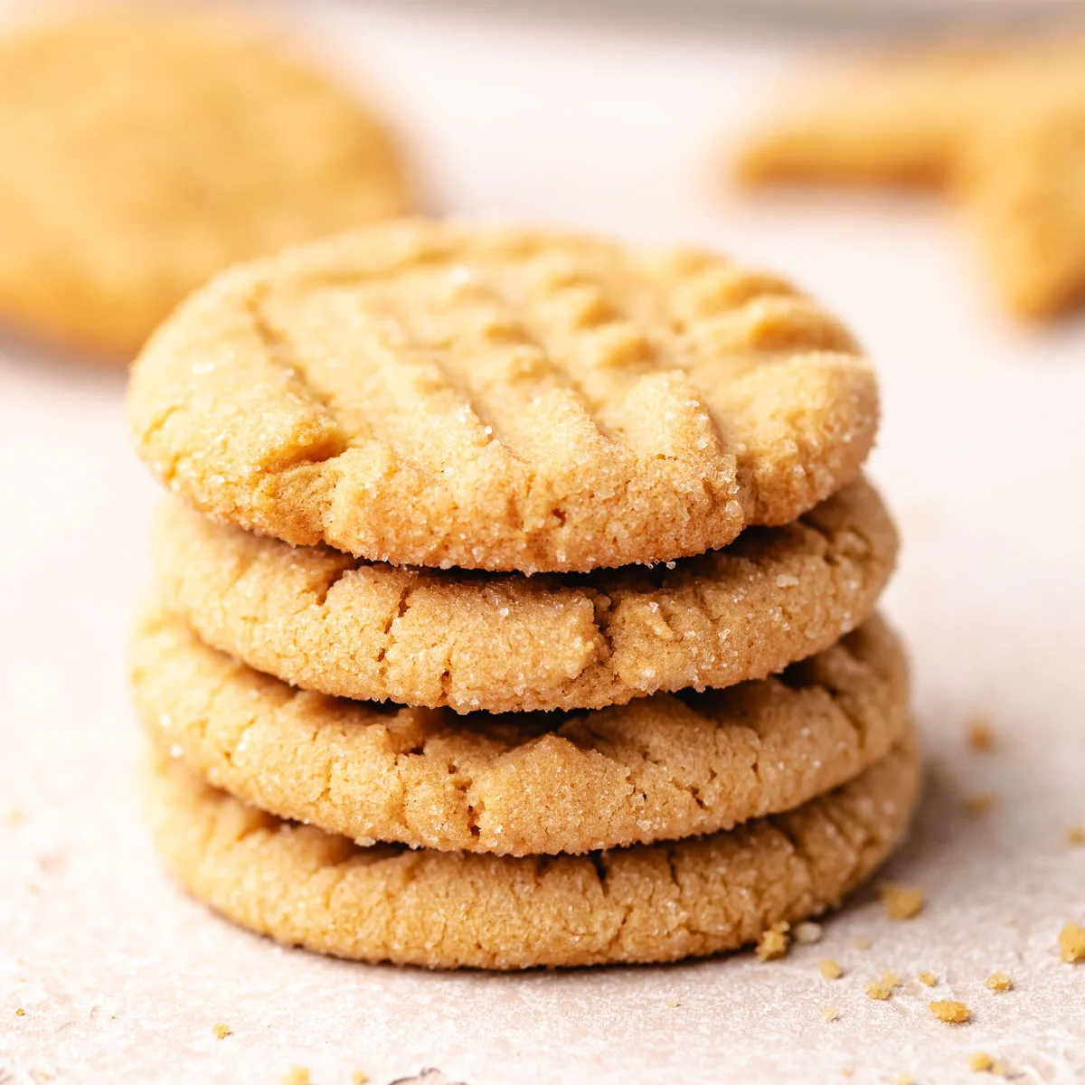 Stack of cookies next to cookie crumbs.