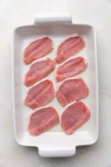 Pork chops in a baking pan.