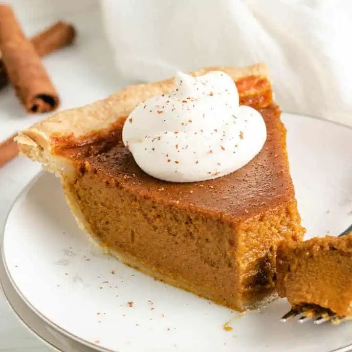 Close up view of a bite taken out of a pumpkin pie.