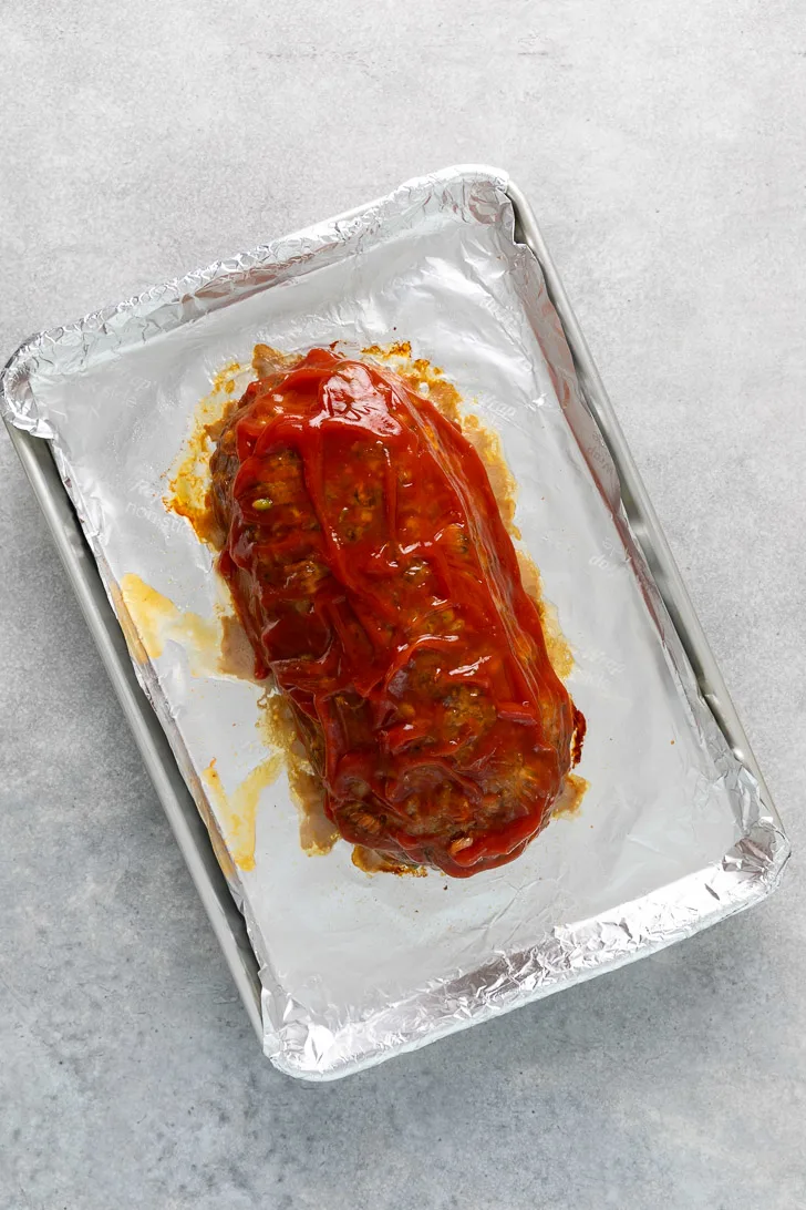 Ketchup brushed over meatloaf.