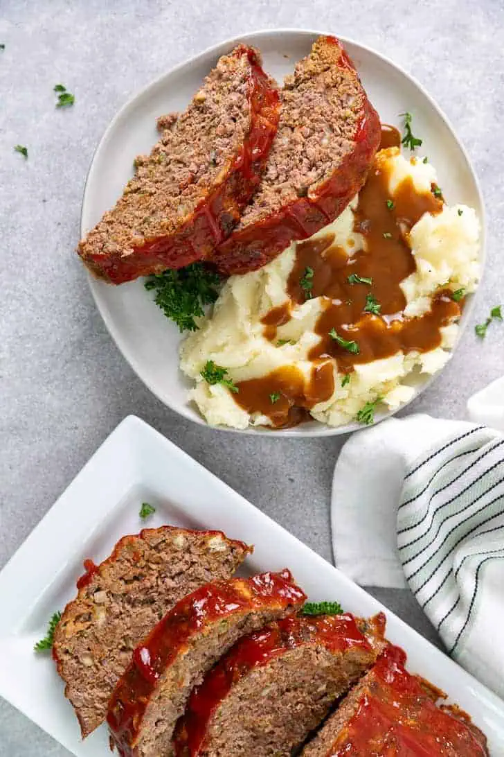 Top down view of meatloaf on a platter and a separate plate.