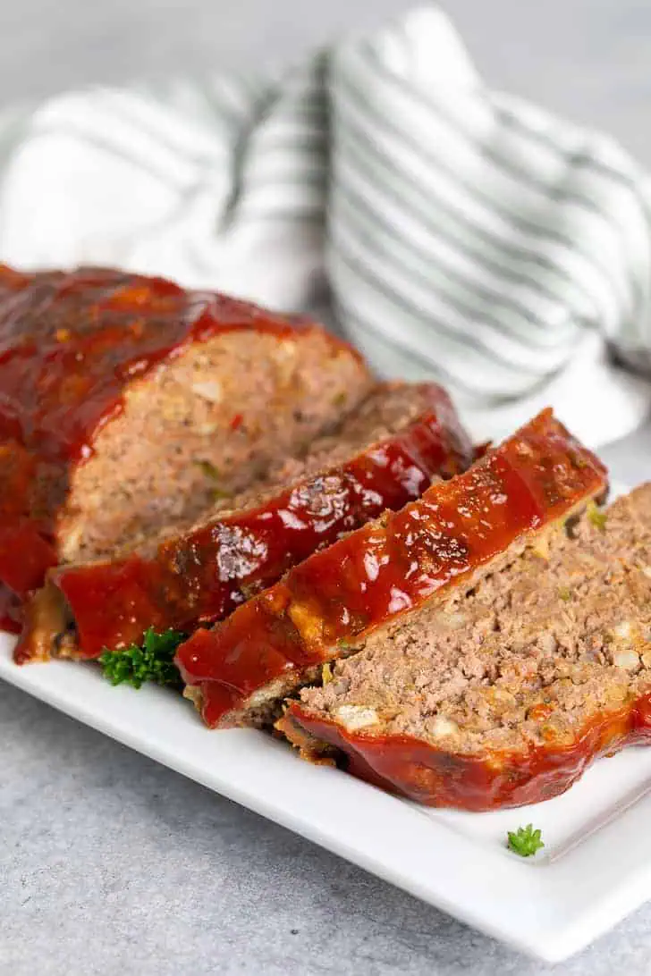 Sliced stove top stuffing meatloaf on a white platter.