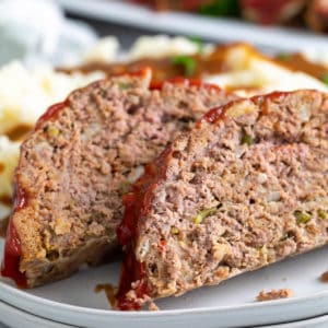 Close up view of two pieces of meatloaf on plates.