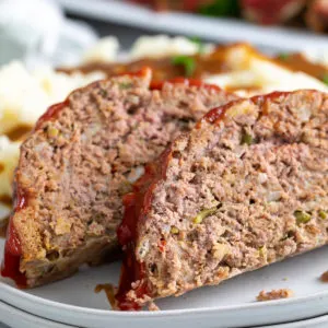 Close up view of two pieces of meatloaf on plates.