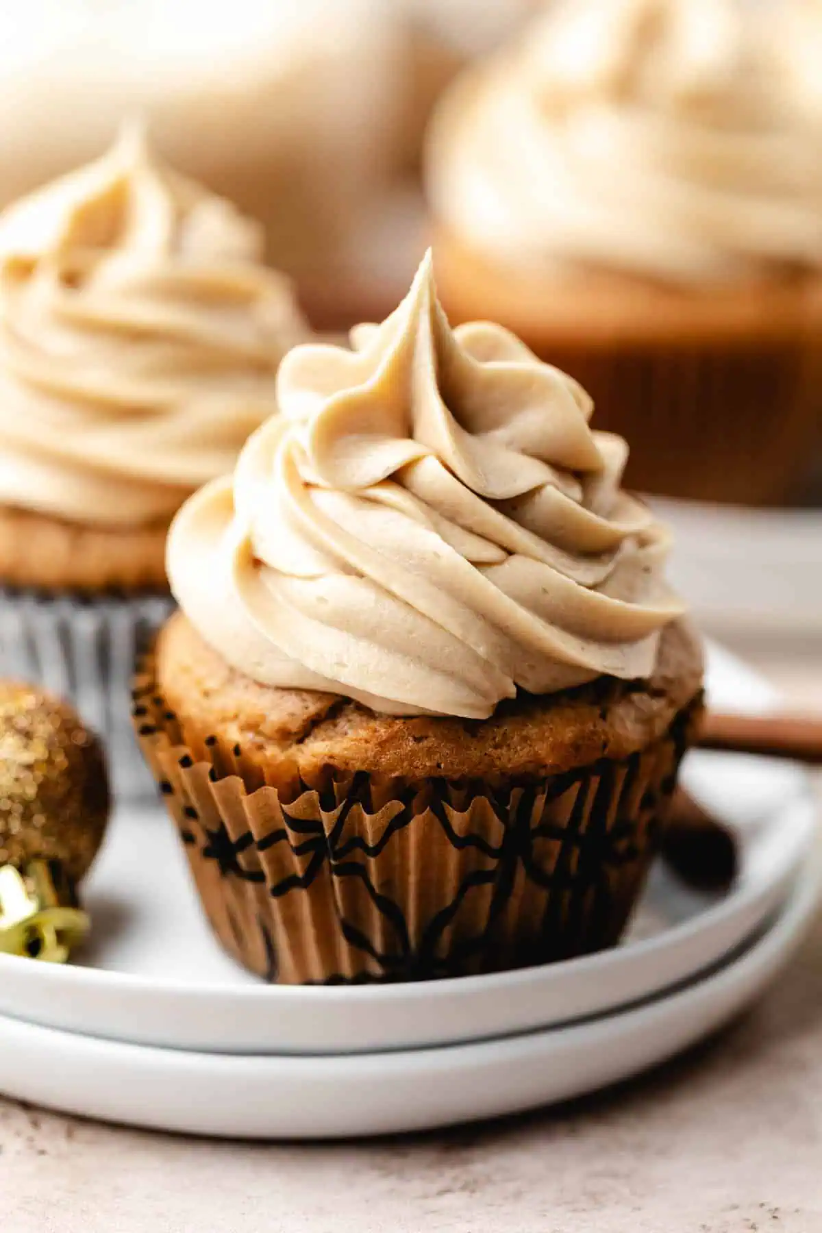 Close up view of an eggnog latte cupcake on a white plate.