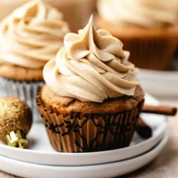 Eggnog latte cupcake on a stack of plates.