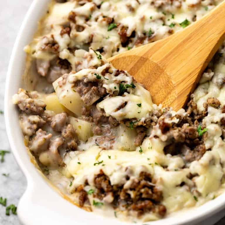 Spoon scooping potatoes and ground beef from a dish.