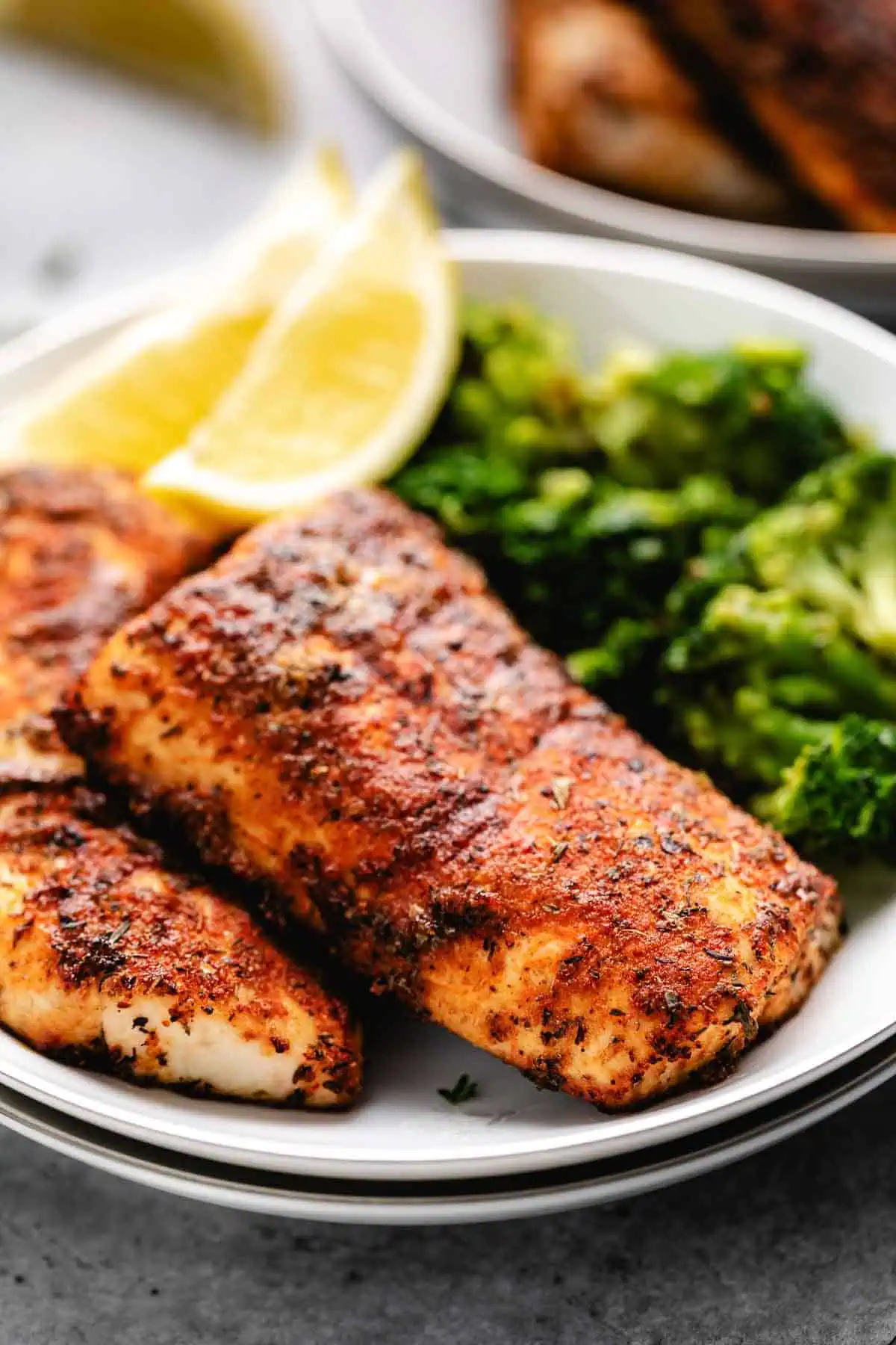 Close up view of fish and lemon on plates.