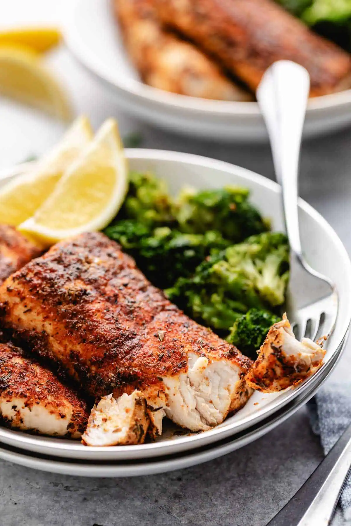 Close up view of mahi mahi on a plate with a fork.