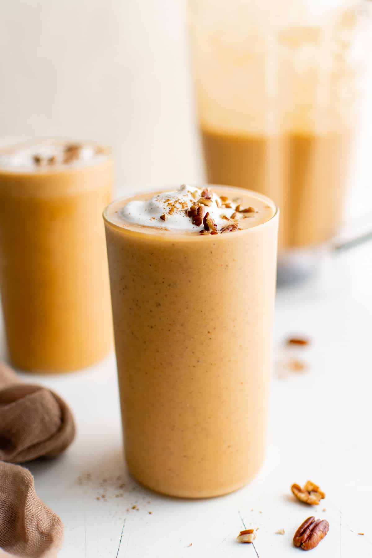 Pumpkin smoothie in a tall drinking glass.