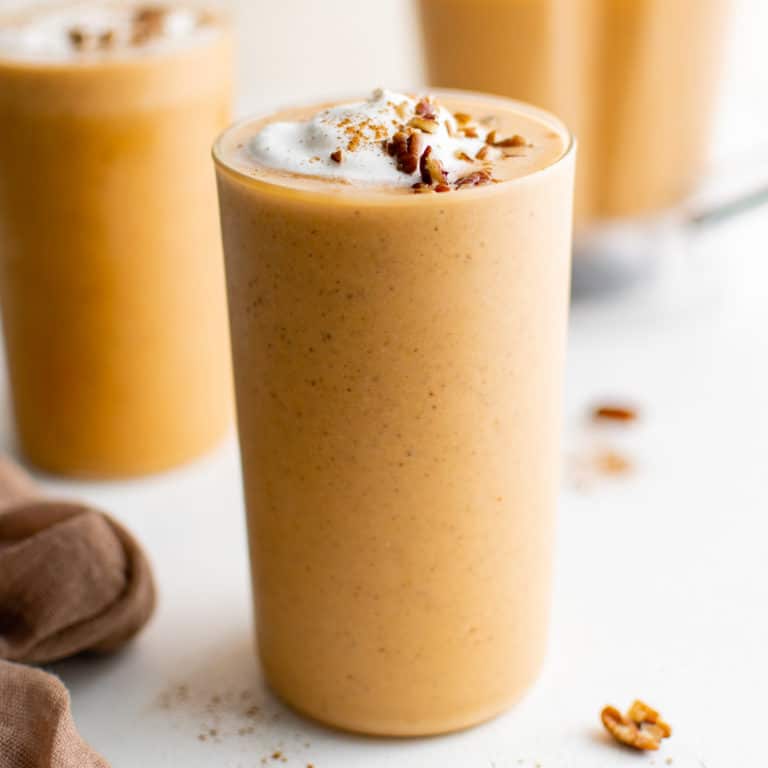 Close up view of a pumpkin smoothie in a tall glass.