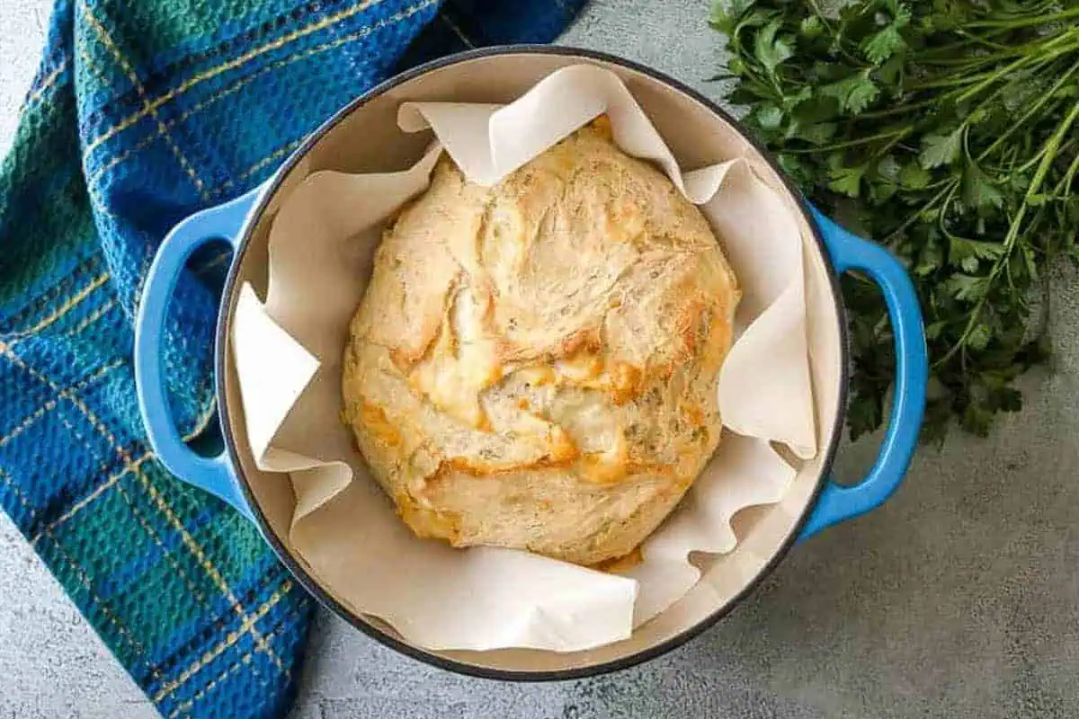 Loaf of baked bread in a dutch oven.