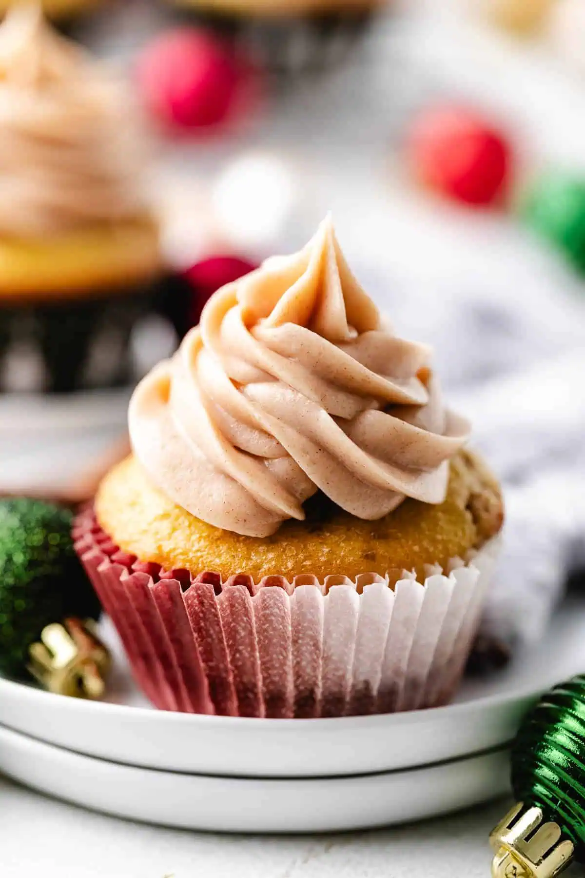 Plate holding a snickerdoodle cupcake with cinnamon frosting.