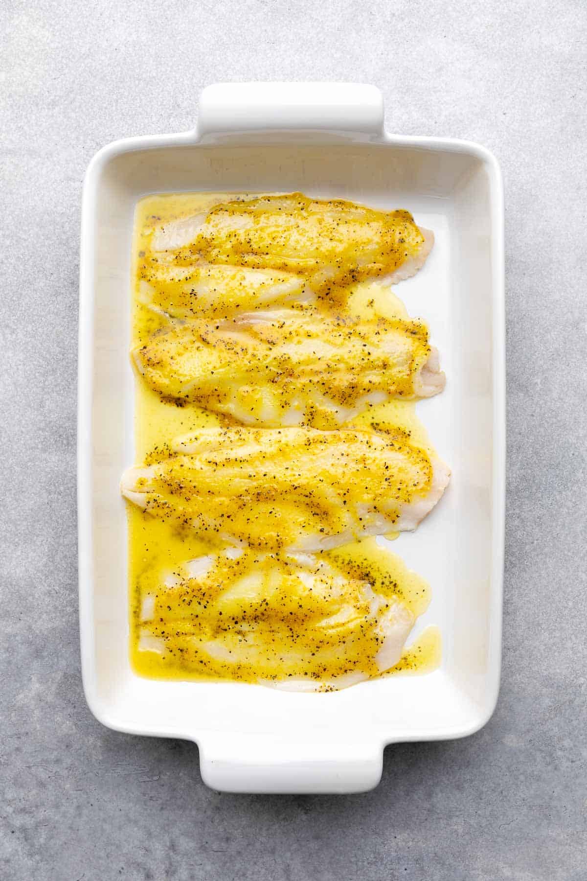 Lemon pepper butter drizzled over fish fillets.