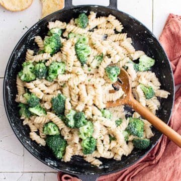 Close up view of pasta and broccoli in a pan.
