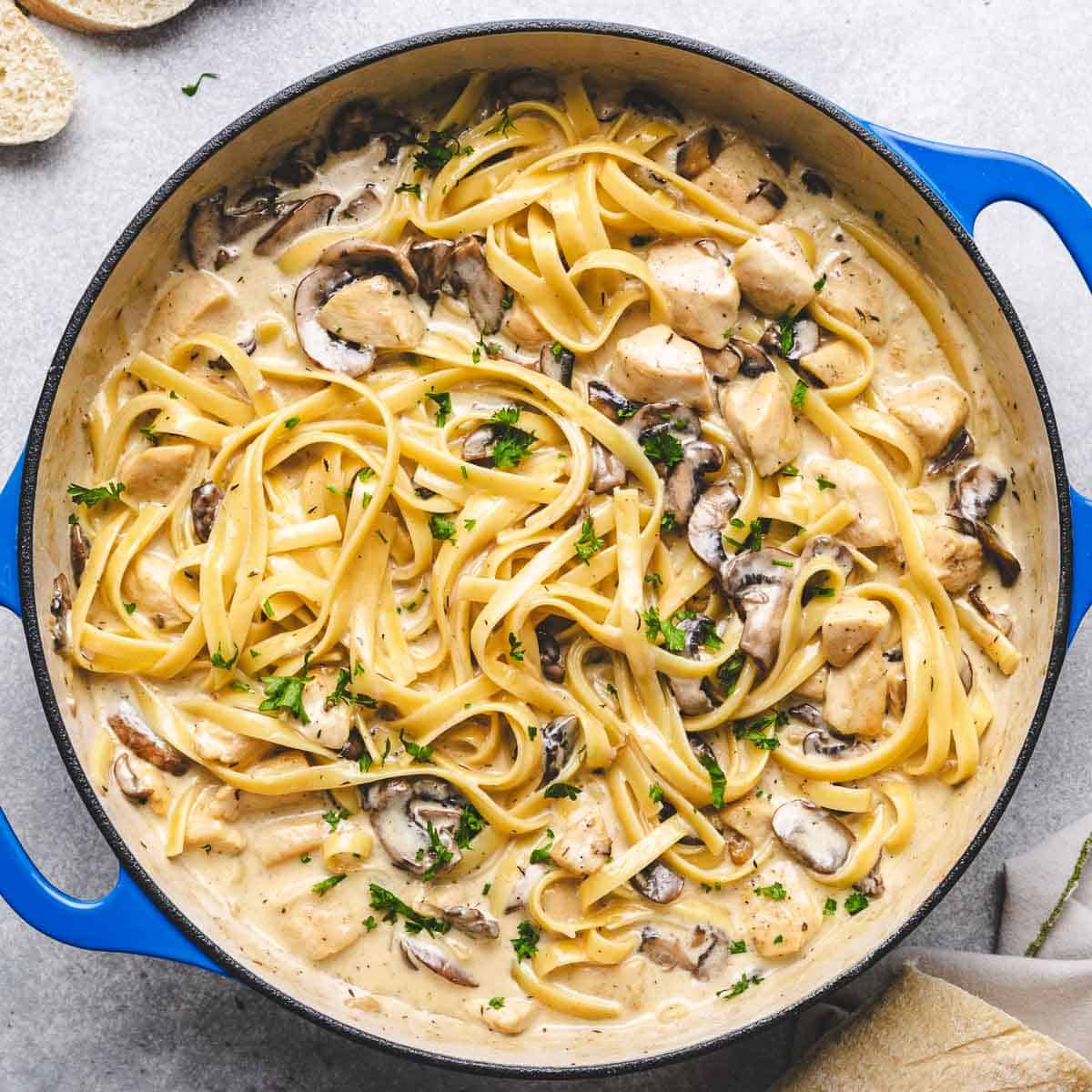 Top down view of chicken and mushroom pasta in a pan.