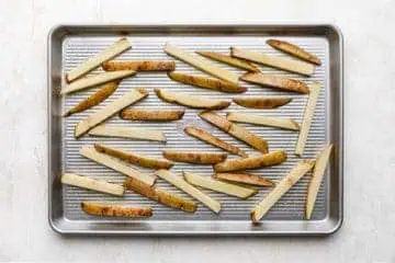 Large sheet pan filled with unbaked fries.