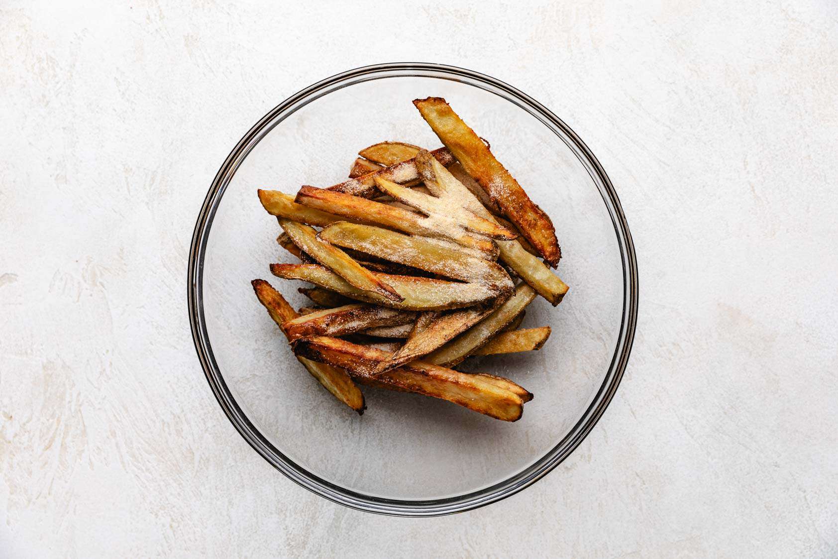 Baked fries with seasonings in a bowl.