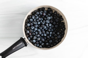 Blueberries, sugar, and water in a pan.