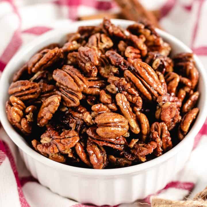 Close up view of a bowl of candied pecans.